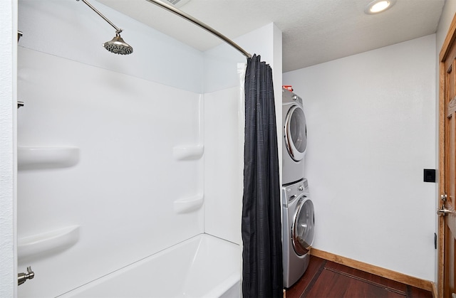 laundry room featuring wood-type flooring and stacked washer / drying machine