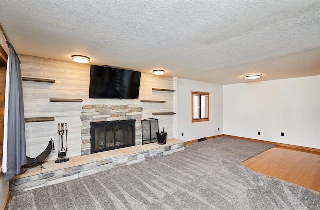 unfurnished living room with carpet flooring, a textured ceiling, and a fireplace