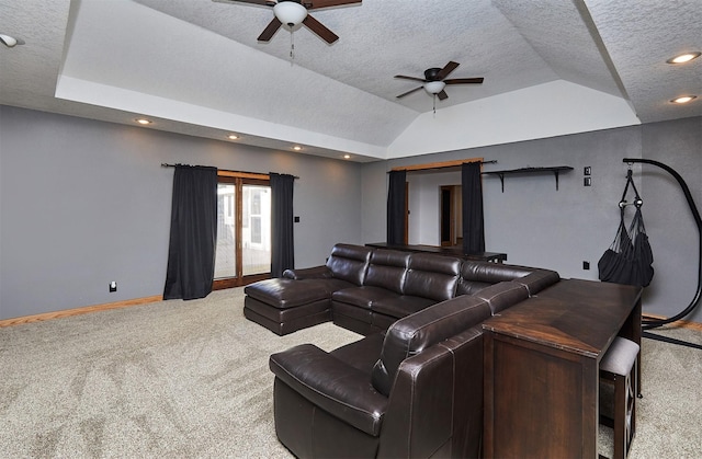 home theater with ceiling fan, a raised ceiling, a textured ceiling, and carpet flooring