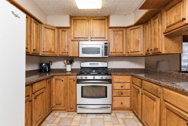 kitchen featuring stainless steel appliances and a textured ceiling