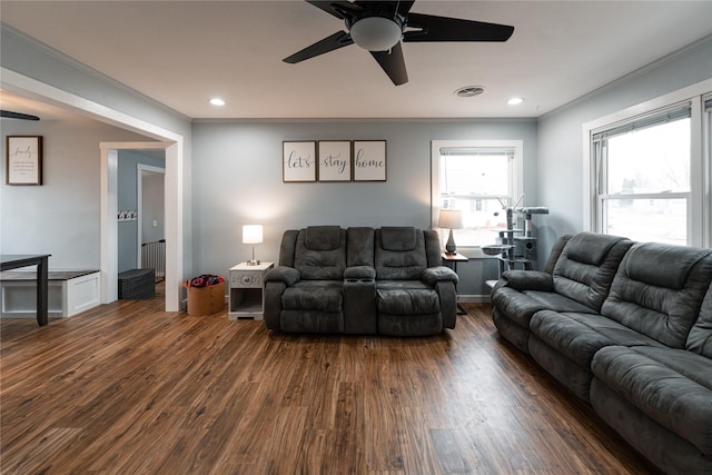 living room featuring dark hardwood / wood-style flooring, crown molding, and ceiling fan