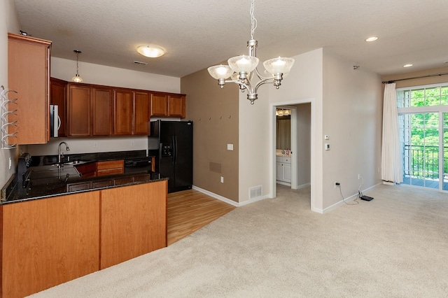 kitchen featuring pendant lighting, light colored carpet, a textured ceiling, and black appliances