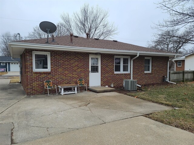 back of property with central AC unit and a patio area