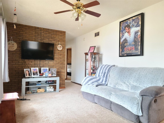 carpeted living room featuring ceiling fan and a textured ceiling