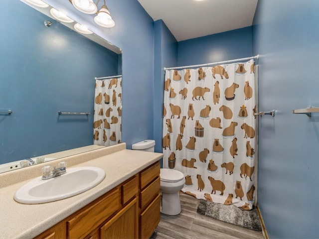 bathroom featuring vanity, wood-type flooring, toilet, and walk in shower