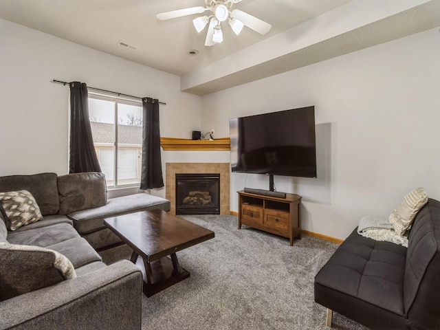 carpeted living room with ceiling fan and a fireplace