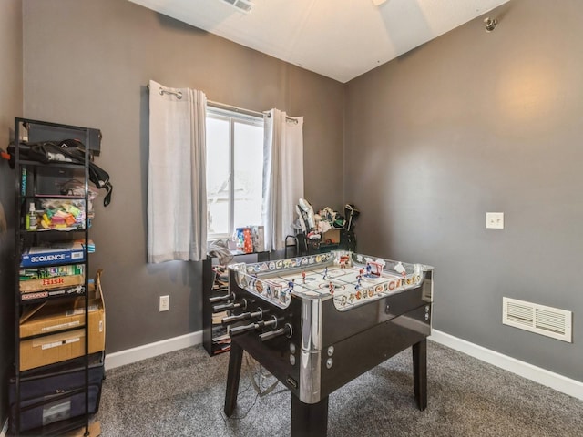 recreation room featuring dark colored carpet