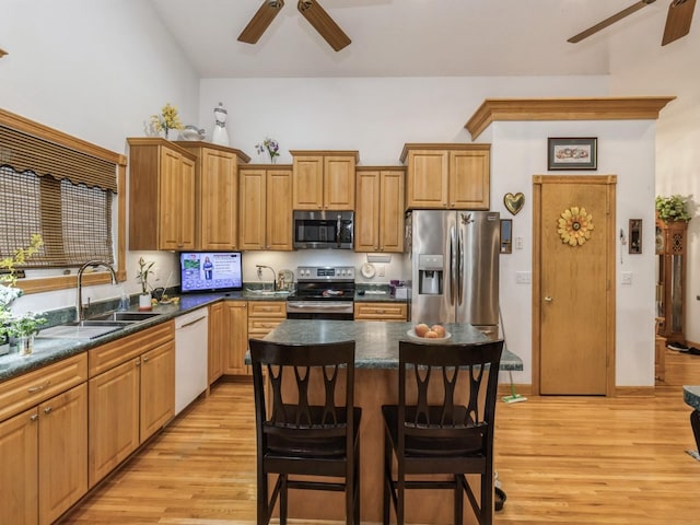 kitchen featuring sink, a kitchen island, ceiling fan, and appliances with stainless steel finishes