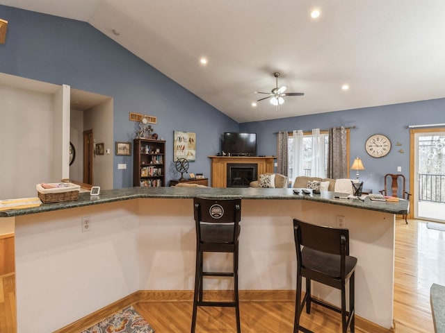 kitchen featuring ceiling fan, a healthy amount of sunlight, light hardwood / wood-style floors, and lofted ceiling