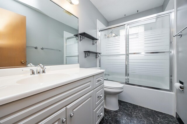 full bathroom featuring vanity, shower / bath combination with glass door, and toilet