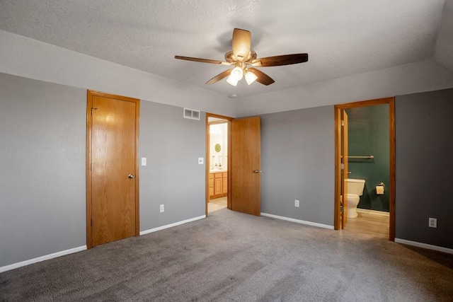 unfurnished bedroom with connected bathroom, light colored carpet, and a textured ceiling