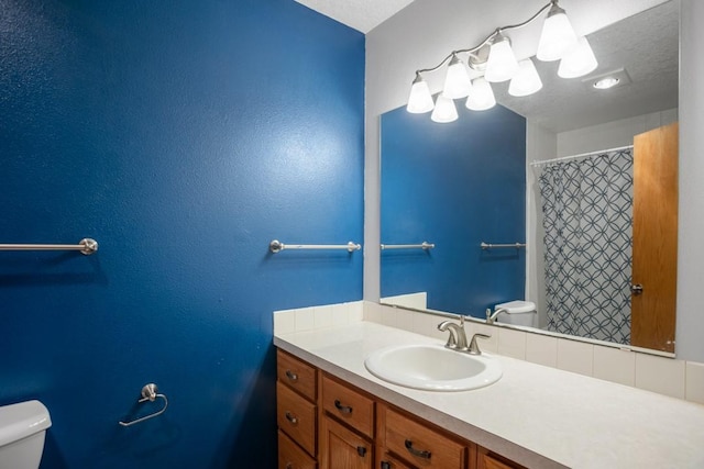 bathroom featuring vanity, a textured ceiling, and toilet