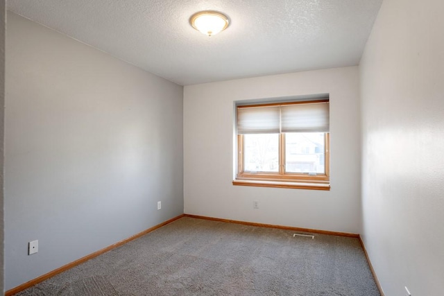 unfurnished room featuring a textured ceiling and carpet flooring