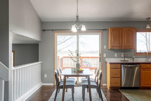 kitchen featuring pendant lighting, a healthy amount of sunlight, dishwasher, and an inviting chandelier