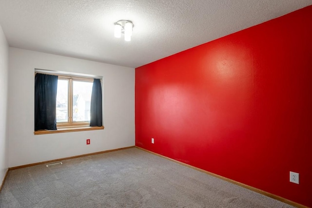 unfurnished room featuring carpet floors and a textured ceiling