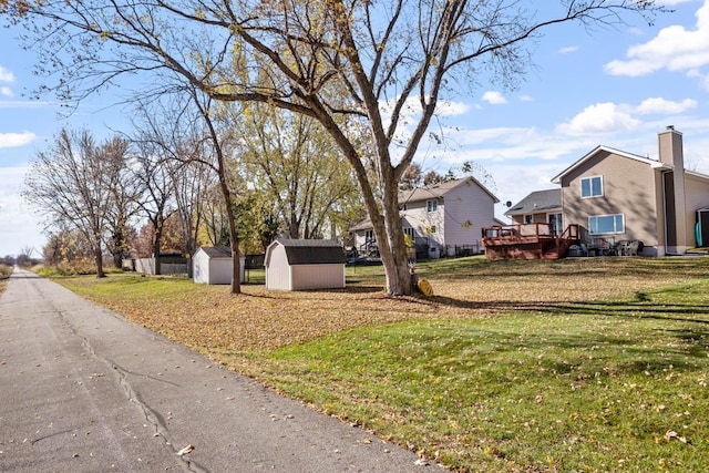 view of yard featuring a wooden deck and a shed