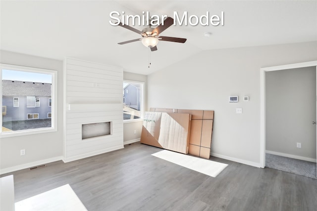 unfurnished living room with hardwood / wood-style floors, vaulted ceiling, and ceiling fan