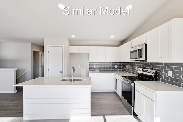 kitchen with stainless steel appliances, a kitchen island with sink, sink, and white cabinets