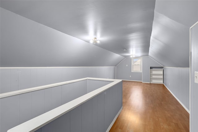 bonus room with lofted ceiling and hardwood / wood-style floors