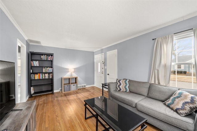 living room with ornamental molding and light wood-type flooring