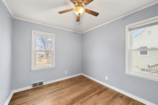 empty room with hardwood / wood-style flooring, ornamental molding, and ceiling fan