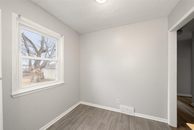 spare room with hardwood / wood-style flooring and a textured ceiling