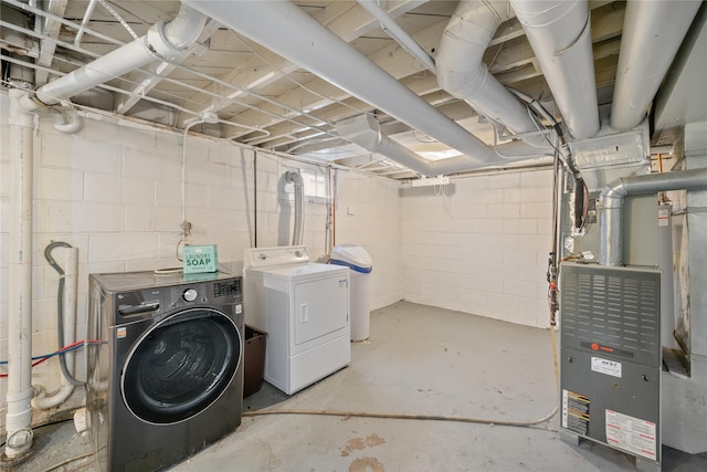 basement featuring washer and clothes dryer and heating unit