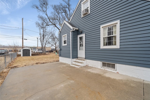 view of home's exterior featuring a storage unit and a patio