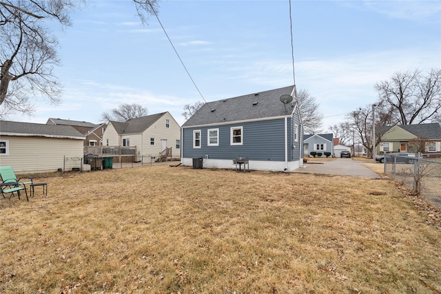 back of property with a yard and central AC