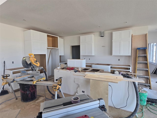 kitchen featuring white cabinetry, a kitchen island, and a textured ceiling