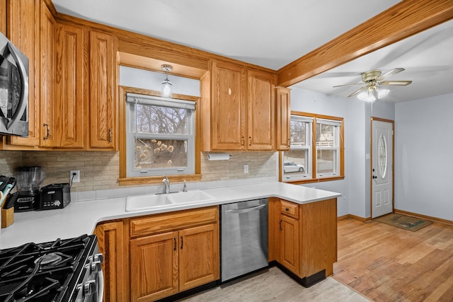 kitchen with appliances with stainless steel finishes, sink, decorative backsplash, and a wealth of natural light