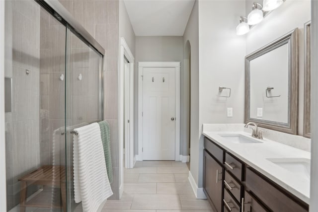 bathroom featuring tile patterned flooring, vanity, and a shower with shower door