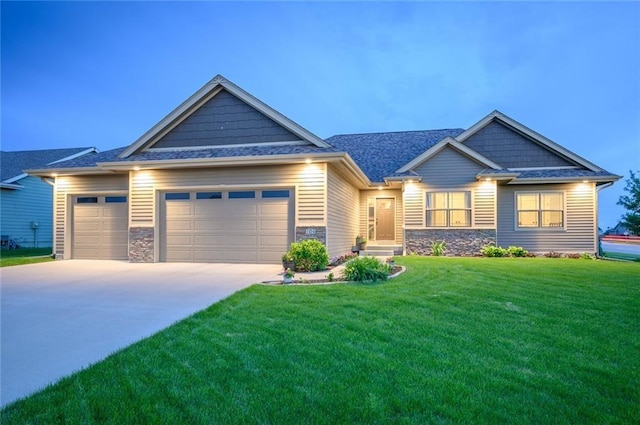 craftsman-style home with a garage, concrete driveway, stone siding, and a front yard