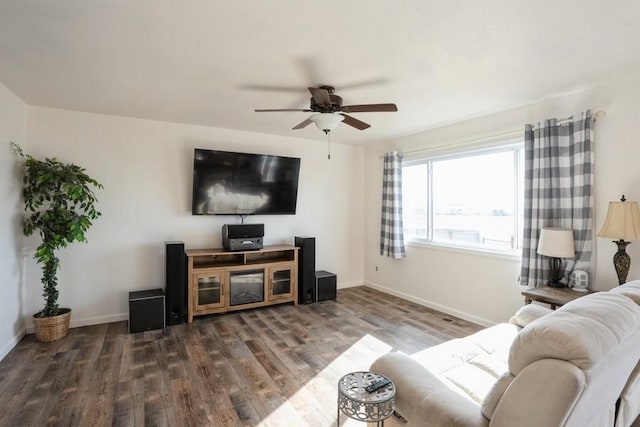 living area featuring ceiling fan, baseboards, and wood finished floors