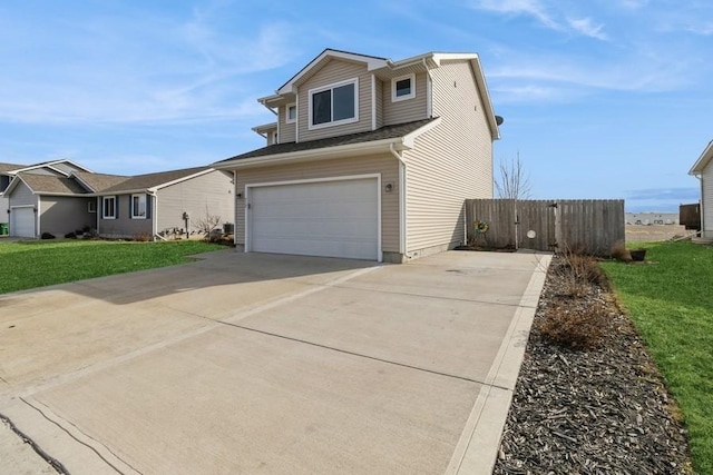 traditional-style home with a front lawn, concrete driveway, and a garage