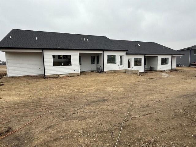 back of house with roof with shingles