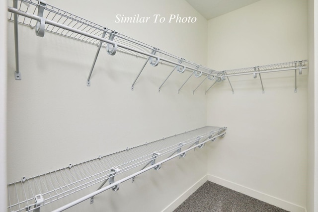 spacious closet with dark carpet