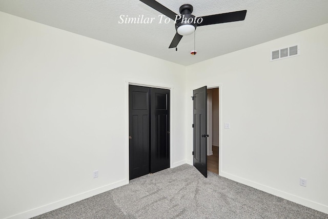 unfurnished bedroom featuring visible vents, carpet floors, a textured ceiling, and baseboards