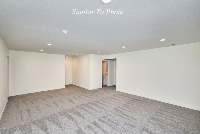 carpeted spare room with recessed lighting, visible vents, baseboards, and a textured ceiling