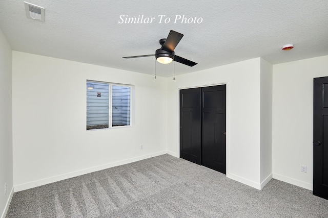 unfurnished bedroom featuring visible vents, baseboards, a textured ceiling, and carpet flooring