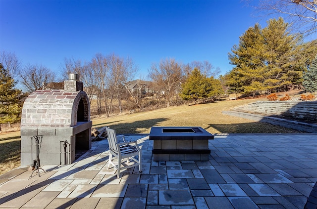 view of patio / terrace with exterior fireplace and a fire pit