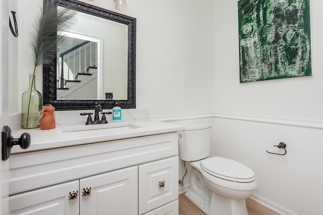 bathroom with vanity, wood-type flooring, and toilet