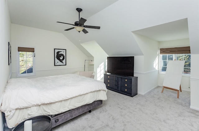 carpeted bedroom featuring ceiling fan, vaulted ceiling, and multiple windows