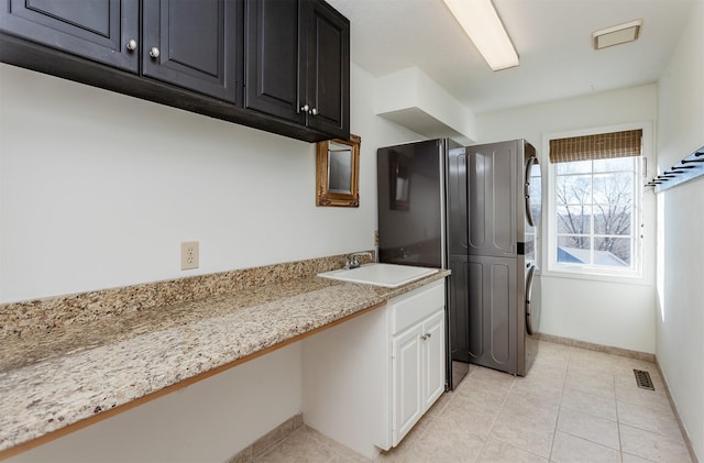 kitchen with light stone counters, sink, white cabinets, and light tile patterned flooring