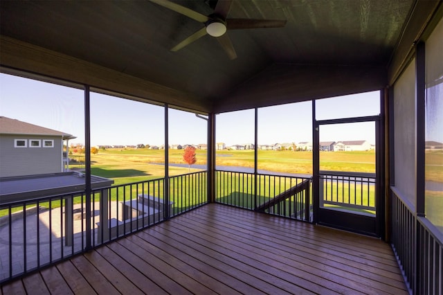 unfurnished sunroom with vaulted ceiling, a healthy amount of sunlight, and ceiling fan