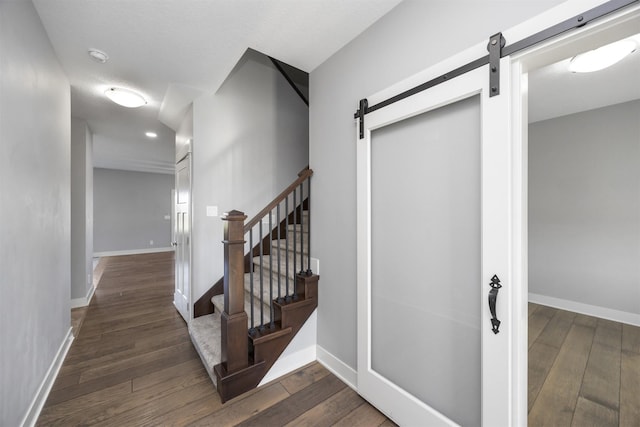 stairway with wood-type flooring and a barn door