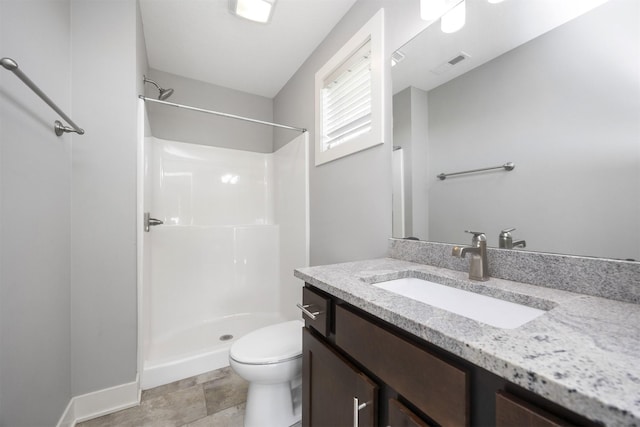 bathroom with vanity, toilet, and a shower