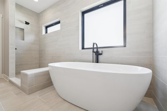 741 Richland Ct, Van Meter, IA 50261 - bathroom with tile walls, tile patterned floors, a tile shower, and a freestanding tub