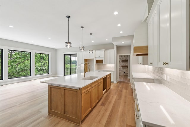 741 Richland Ct, Van Meter, IA 50261 - kitchen featuring light wood-style flooring, decorative backsplash, recessed lighting, and an island with sink