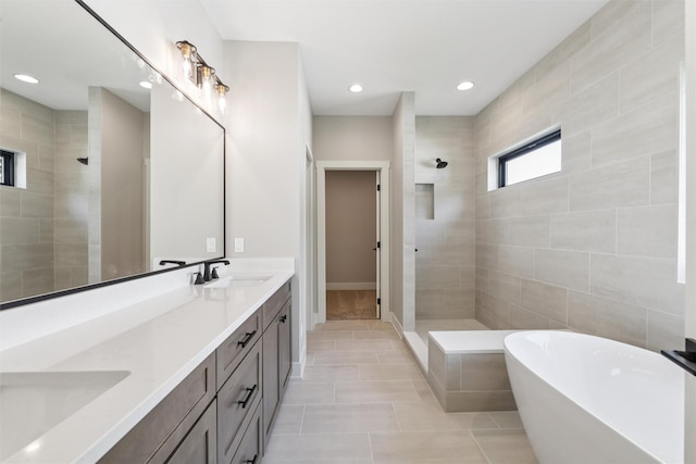741 Richland Ct, Van Meter, IA 50261 - bathroom featuring a walk in shower, double vanity, a soaking tub, tile patterned flooring, and recessed lighting